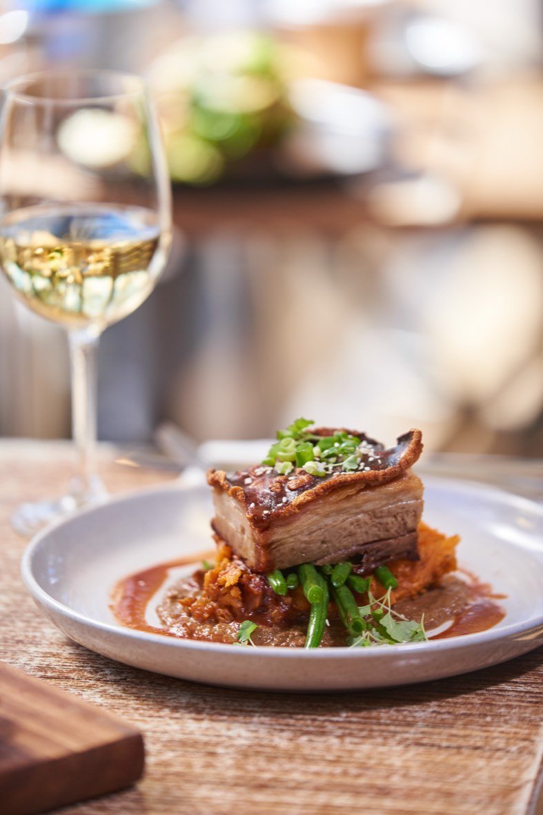 Pork belly plate with a glass of white wine