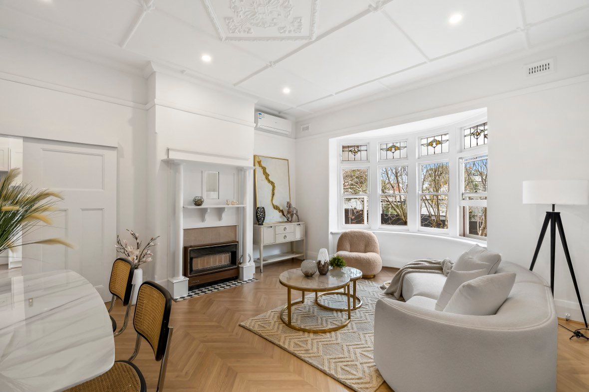 Period living room with fireplace and bay window