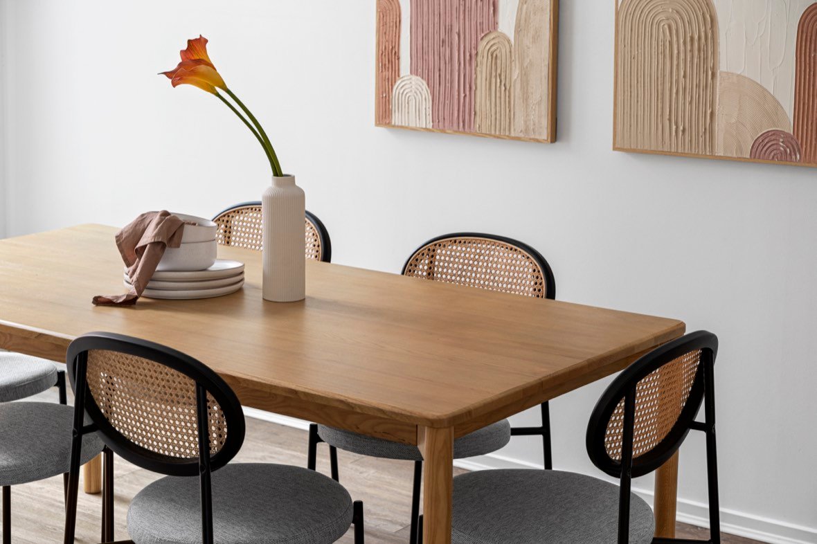 Dining setting with rattan chairs and artwork